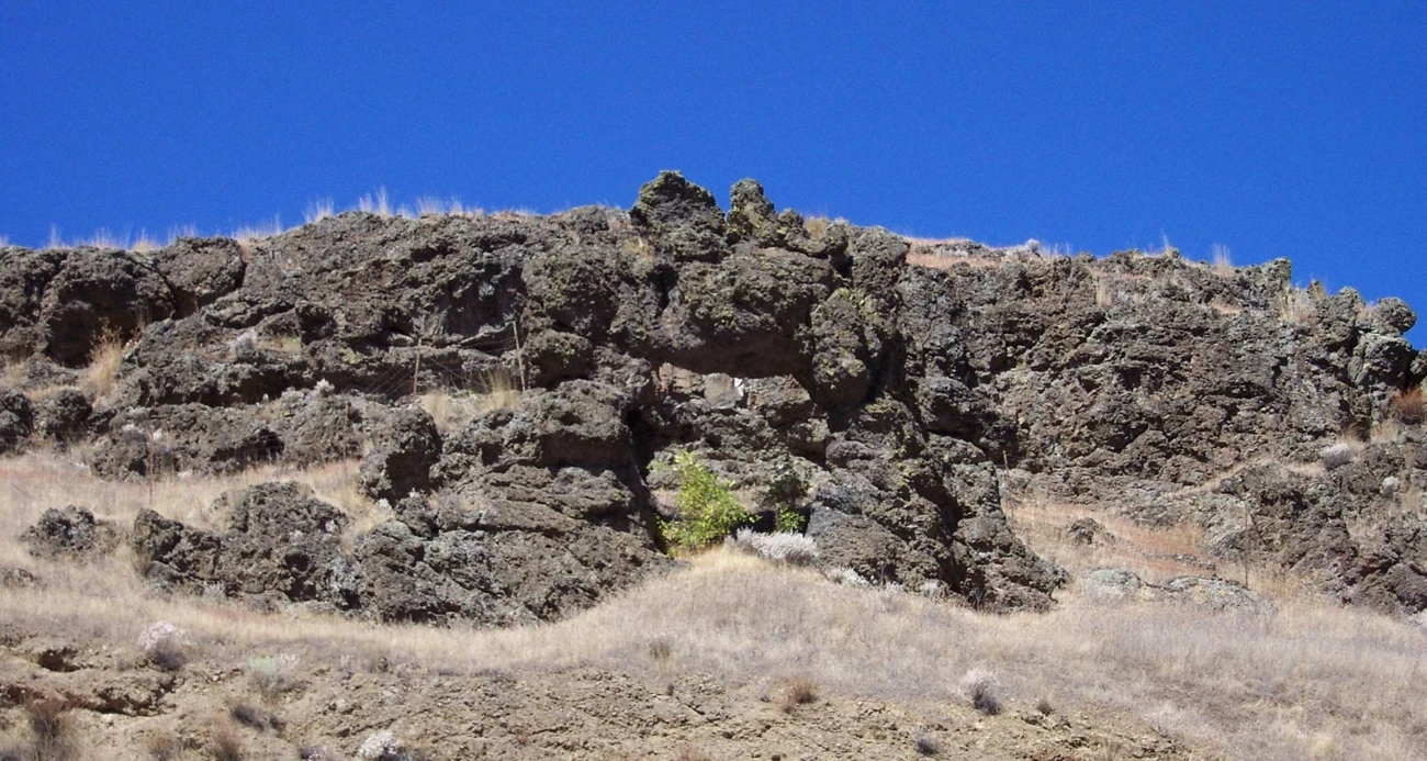 A basalt outcrop and autumn trees at a Nez Perce story site.