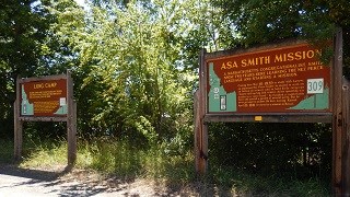 Two interpretive signs for Asa Smith Mission and Long Camp on a highway pullout.
