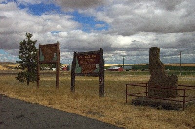 A highway pullout with two interpretive signs and a monument shaped like Idaho.