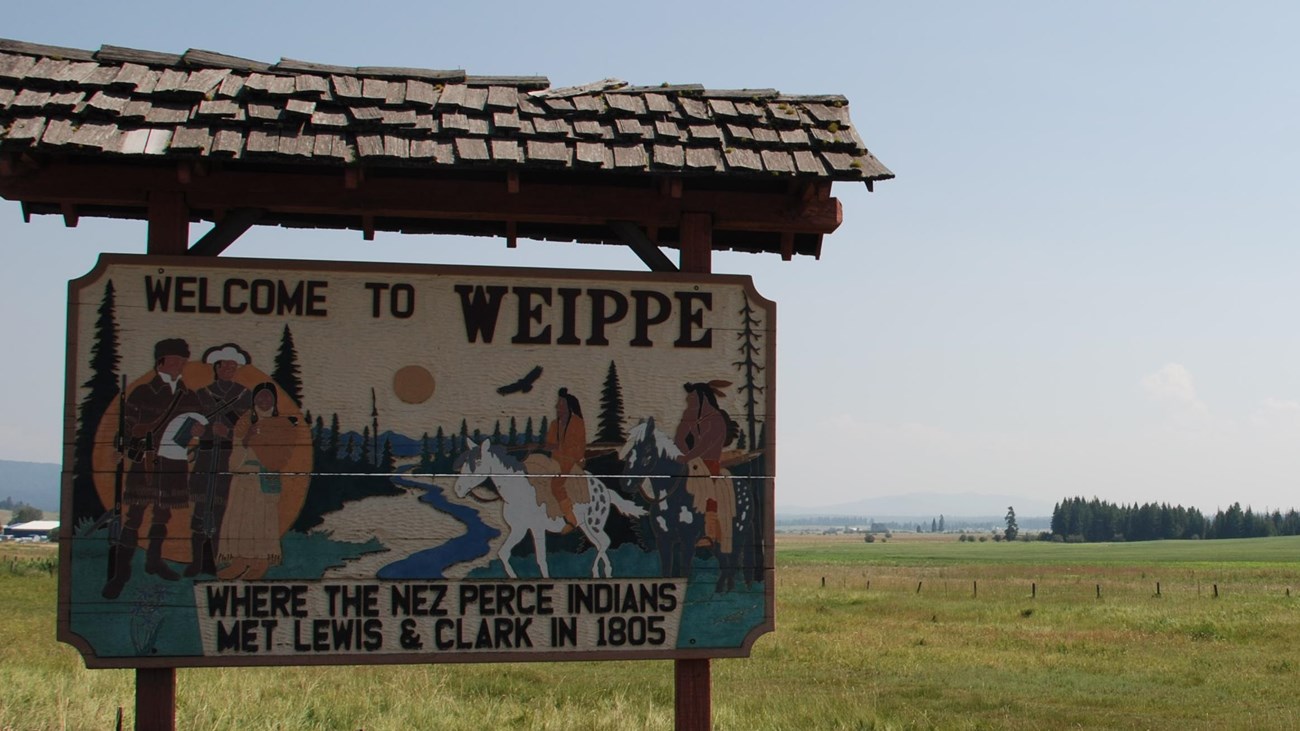 A wooden sign reading 'Welcome to Weippe where the Nez Perce Indians met Lewis and Clark in 1805.'
